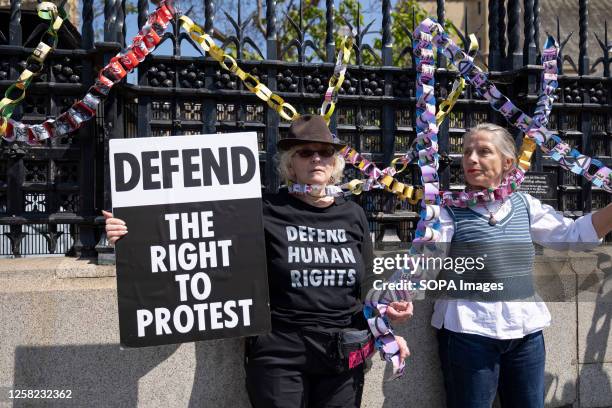 Protesters with placards symbolically lock themselves outside the UK Parliament with paper chains during the demonstration. Various activists groups,...