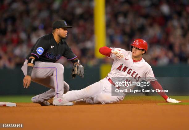Shohei Ohtani of the Los Angeles Angels beats the throw to Luis Arraez of the Miami Marlins for a stolen base in the seventh inning at Angel Stadium...