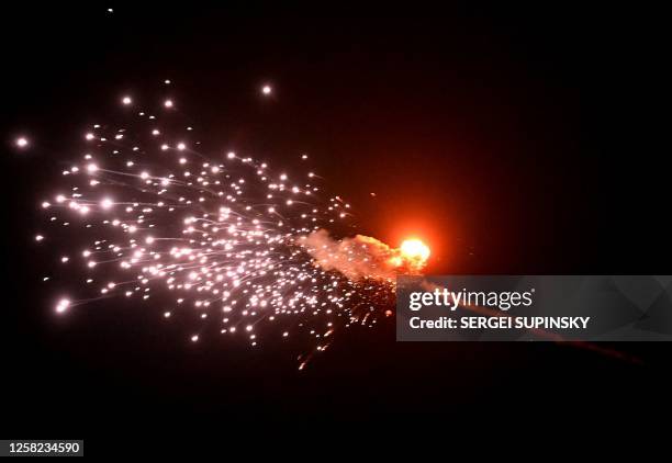 This photograph taken on May 28 in Kyiv, shows the explosion of a drone after it was shot down during a massive Russian drones strike mainly...