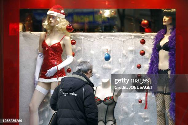 Passer-by looks at a Christmas sex-shop window in Pigalle red quarter in Paris on December 22, 2010. AFP PHOTO JOEL SAGET