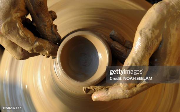 An Indian potter makes earthenware oil pots or 'diyas' at his workshop on the outskirts of Hyderabad on October 13 prior to The Diwali Festival - The...