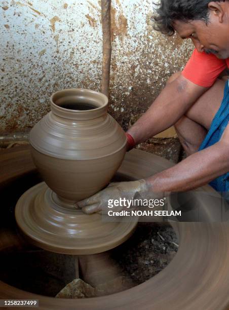 An Indian potter prepares earthenware pots at Kummara Basthi in Hyderabad on March 17, 2008. Earthenware pots or Matkas which are also known as 'the...