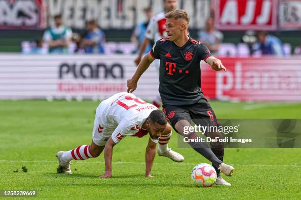 Joshua Kimmich of Bayern Muenchen and Linton Maina of 1. FC Koeln battle for the ball during the Bundesliga match between 1. FC Köln and FC Bayern...