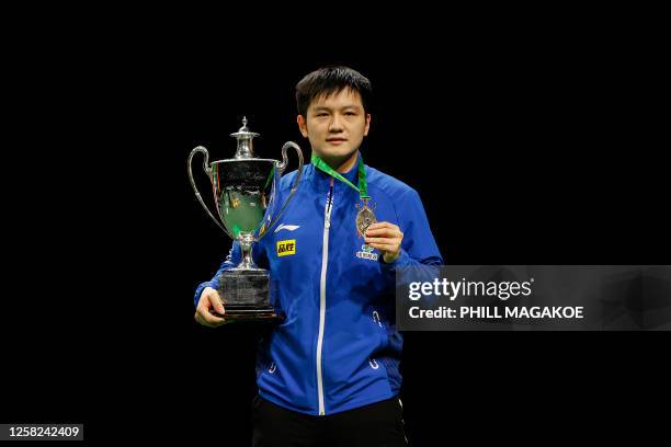 Gold medallist China's Fan Zhendong holds the trophy on the podium following the men's singles table tennis final match at the 2023 ITTF World Table...