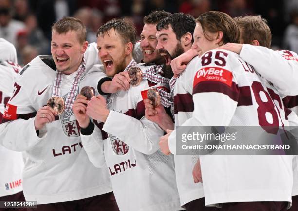 Latvia's team celebrates with the bronze medal after winning the IIHF Ice Hockey Men's World Championships third place play-off match betweeen United...