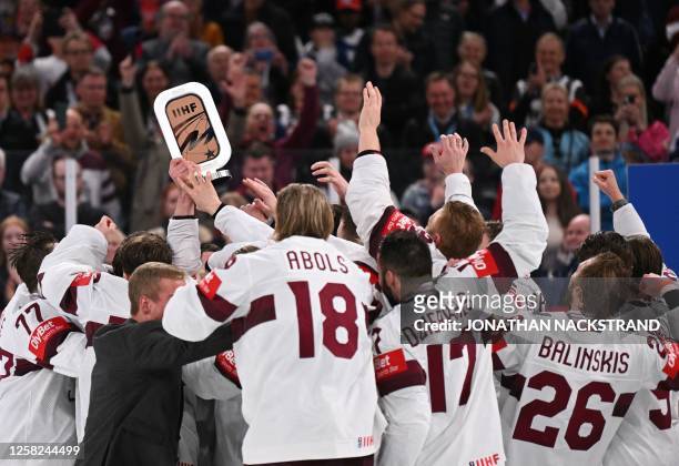 Latvia's team celebrates with the bronze trophy after winning the IIHF Ice Hockey Men's World Championships third place play-off match betweeen...