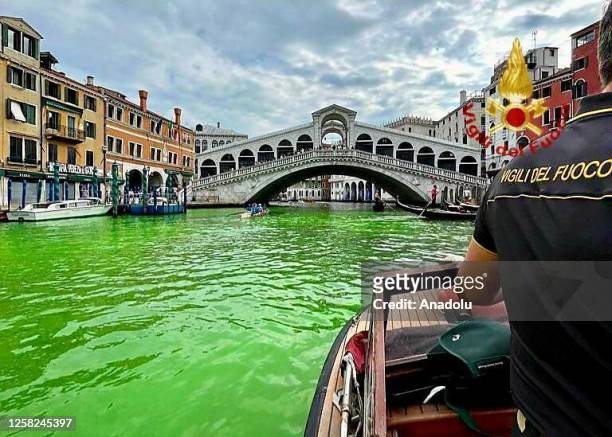 View of a part of water of Grand Canal appeared to have turned bright green as the Rialto Bridge is seen in Venice, Italy on May 28, 2023. The...