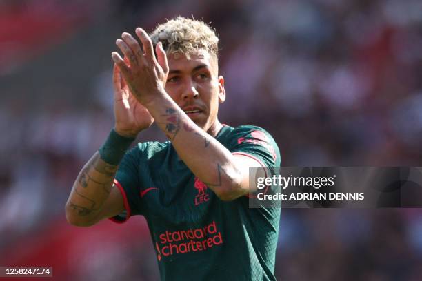 Liverpool's Brazilian striker Roberto Firmino applauds fans as he leaves on his final Liverpool appearance during the English Premier League football...
