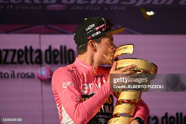 Jumbo-Visma's Slovenian rider Primoz Roglic kisses the race's winner's "Trofeo Senza Fine" as he celebrates on the podium after winning the Giro...