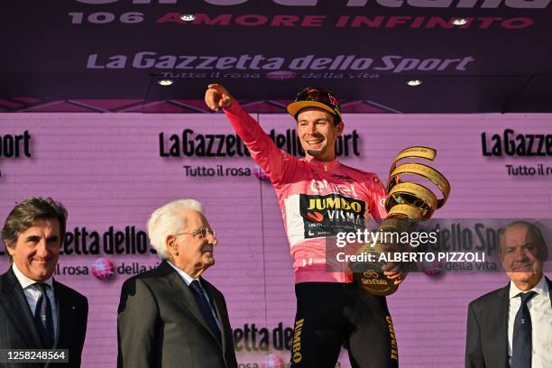 Jumbo-Visma's Slovenian rider Primoz Roglic celebrates on the podium with the race's winner's "Trofeo Senza Fine" , as Founder of Italian media and...
