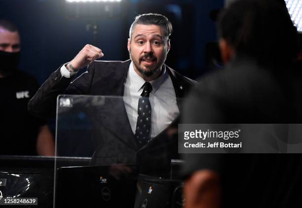 Fighter and analyst Dan Hardy speaks with referee Herb Dean after the conclusion of the lightweight fight between Francisco Trinaldo and Jai Herbert...