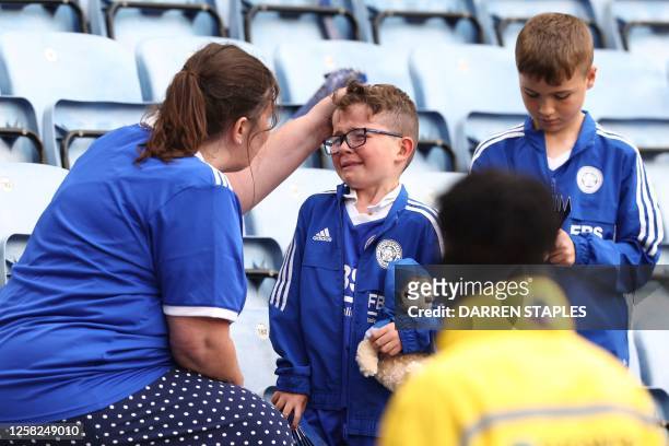 Leicester City's fan is consoled at the end of the English Premier League football match between Leicester City and West Ham United at King Power...
