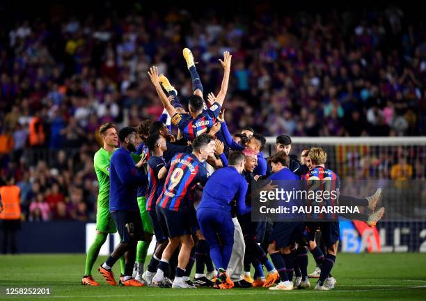 Barcelona's players lift Spanish midfielder Sergio Busquets and Barcelona's Spanish defender Jordi Alba during a tribute at the end of the Spanish...