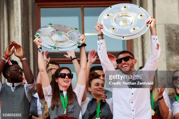 Sarah Zadrazil and Lucas Hernandez celebrate with the FLYERALARM Frauen-Bundesliga and Bundesliga trophies during the official championship...