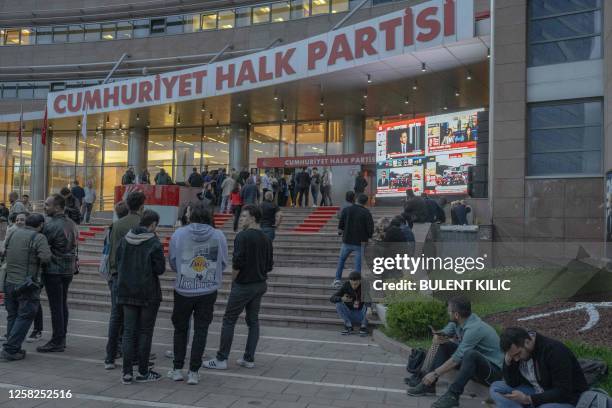 Onlookers gather to view a bank of televisions showing a broadcast of Turkish President Recep Tayyip Erdogan as he makes his victory speech, at...