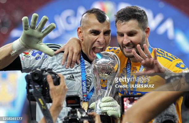Tigres' Argentine goalkeeper Nahuel Guzman and French forward Andre-Pierre Gignac pose with the trophy after winning the Mexican Clausura football...