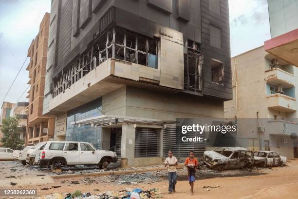 Children walk past the burnt-down headquarters of Sudan's Central Bureau of Statistics on al-Sittin road in the south of Khartoum on May 29, 2023....