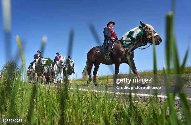 May 2023, Bavaria, Bad Kötzting: Participants of the Kötztinger Pfingstritt ride with their horses on a road. The procession is one of the oldest...