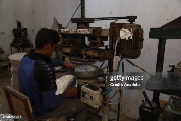 Child makes plates from waste paper at wasted paper recycling facilities in the areas of Sermada and Killi in northern Idlib, Syria on May 4, 2023....