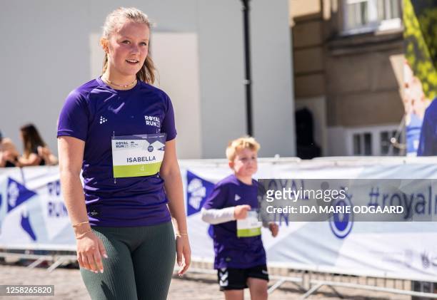 Denmark's Princess Isabella reacts after crossing the finish line at Amalienborg Castle Square after participating in a One Mile Family run during...