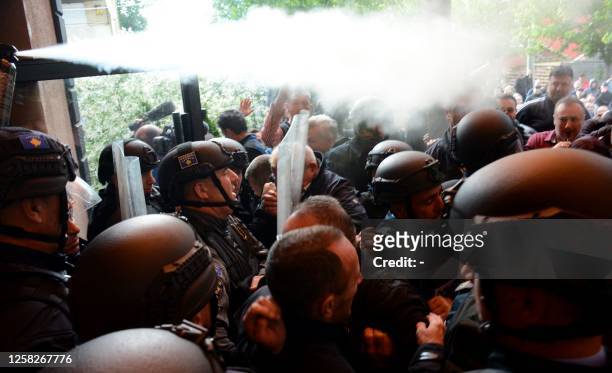 Kosovo riot police along with KFOR military police, secure access to a municipal building in Zvecan as Kosovo Serbs gather outside the building after...