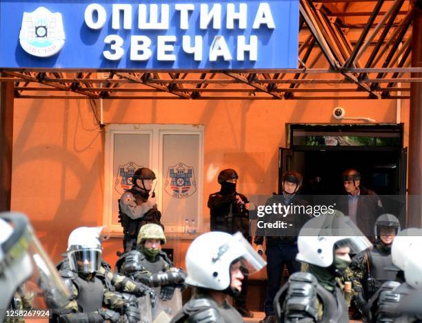 Kosovo riot police along with KFOR military police, secure access to a municipal building in Zvecan as Kosovo Serbs gather outside the building after...