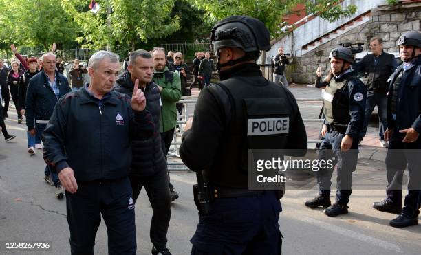 Kosovo riot police along with KFOR military police, secure access to a municipal building in Zvecan as Kosovo Serbs gather outside the building after...