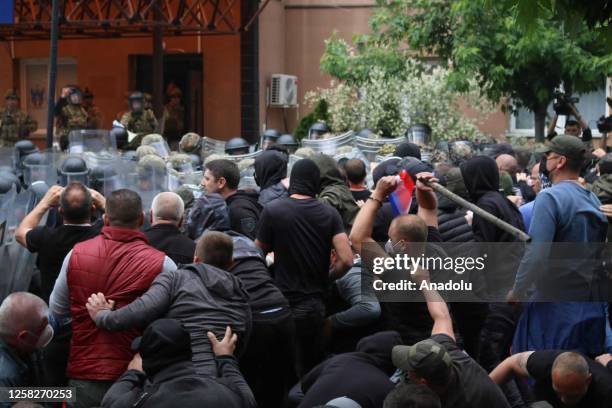 Kosovo riot police along with KFOR military police, secure access to a municipal building in Zvecan as Kosovo Serbs gather outside the building after...