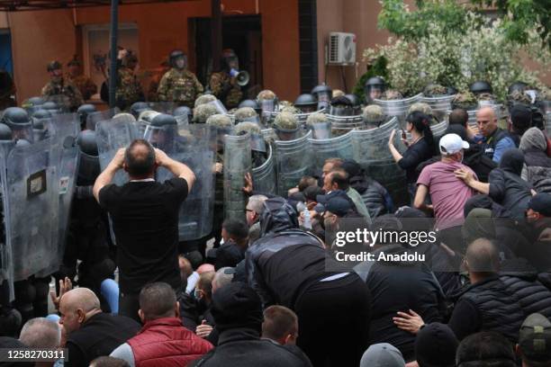 Kosovo riot police along with KFOR military police, secure access to a municipal building in Zvecan as Kosovo Serbs gather outside the building after...