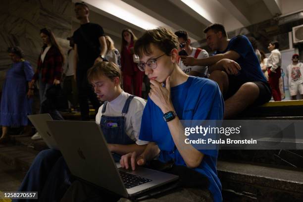 Technicians Kiril and Illia work on their computers while sheltering in the Kyiv metro underground station with other Kyiv residents during the...