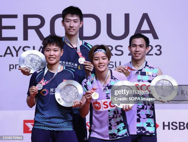 Huang Dong Ping, Feng Yan Zhe of China, Dechapol Puavaranukroh, Sapsiree Taerattanachai of Thailand pose with their winner medals at the podium after...