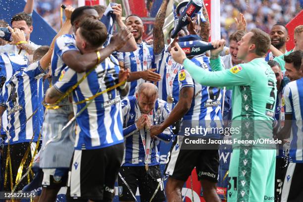 Barry Bannan of Sheffield Wednesday wipes the champagne of his face as his team mates celebrate victory during the Sky Bet League One Play-Off Final...