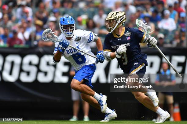 Jack Simmons of the Notre Dame Fighting Irish charges with the ball while defended by Jake Caputo of the Duke University Blue Devils during the...