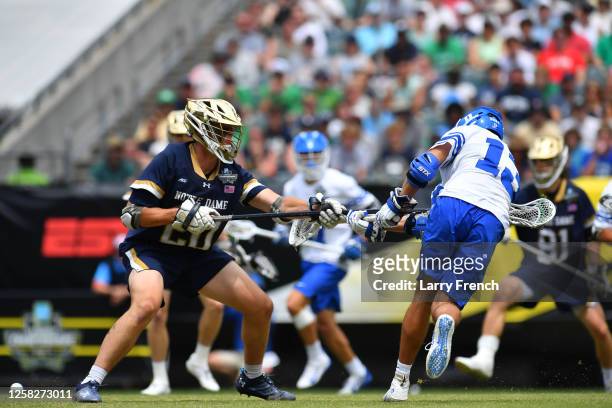 Owen Caputo of the Duke University Blue Devils shoots the ball against defenseman Chris Conlin of the Notre Dame Fighting Irish during the Division I...