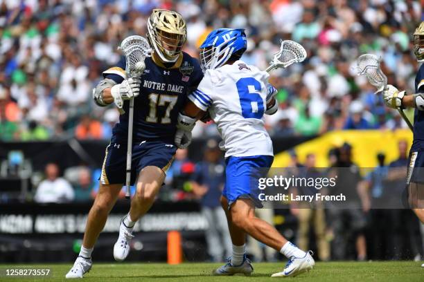 Reilly Gray of the Notre Dame Fighting Irish charges past Jake Caputo of the Duke University Blue Devils during the Division I Men's Lacrosse...