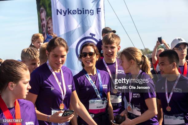 Crown Princess Mary of Denmark with participants after she crossed the finish line of the Royal Run event on a running wheel on May 29, 2023 in...