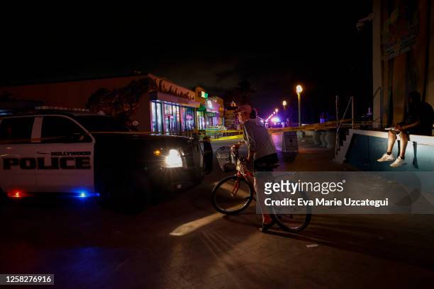 Beachgoers are seen next to a crime scene tape as law enforcement officers respond to a shooting at Hollywood Beach on May 29, 2023 in Hollywood,...