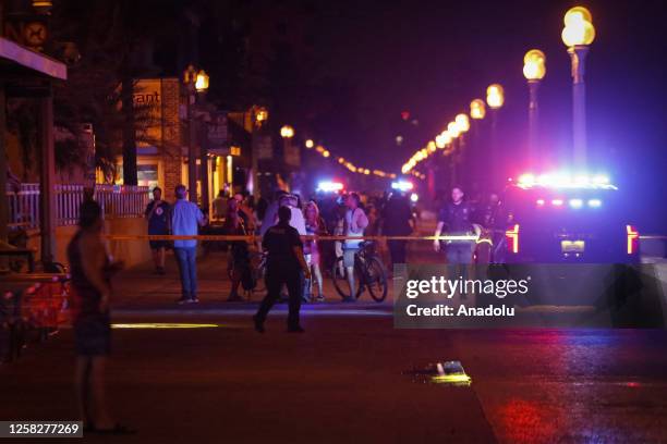 Bystanders and Hollywood Police officers are seen nearby the shooting scene after an altercation ended in gunfire at Hollywood Beach Broadwalk in...