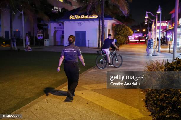 Hollywood Police officer investigates at the shooting scene after an altercation ended in gunfire at Hollywood Beach Broadwalk in Hollywood, Florida,...
