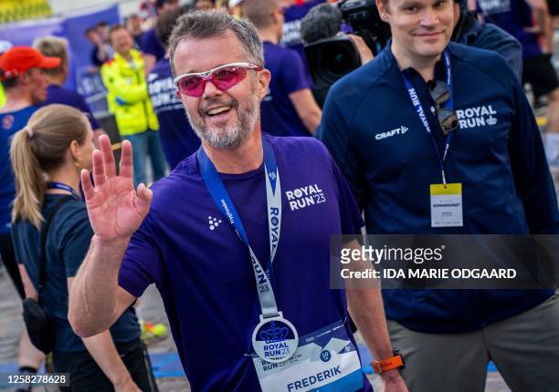 Crown Prince Frederik of Denmark waves as he runs across the 10 km finish line during the yearly Royal Run in Copenhagen on May 29, 2023. / Denmark...