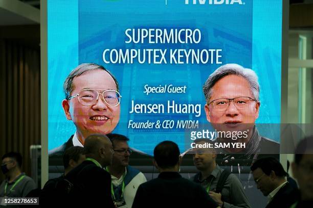 Visitors are seen in front of a screen showing the images of Jensen Huang , CEO of NVIDIA, and Charles Liang, Founder and President of the...