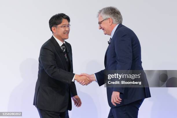 Martin Daum, chief executive officer of Daimler Trucks AG, right, and Koji Sato, president of Toyota Motor Corp., shake hands during a news...