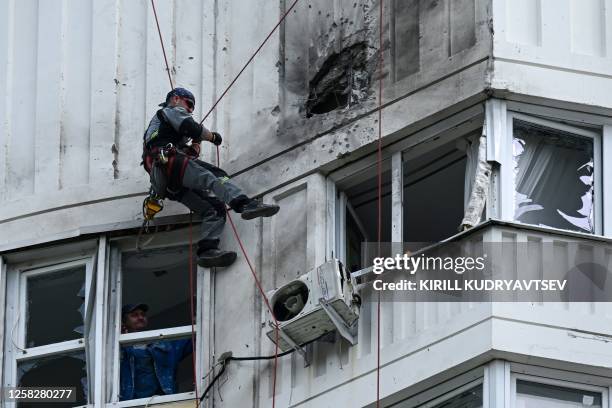 Specialist inspects the damaged facade of a multi-storey apartment building after a reported drone attack in Moscow on May 30, 2023.