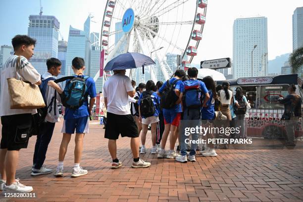 People queue for ice-cream in the heat in Hong Kong on May 30 after a new heat alert was issued along with an amber warning for outdoor workers under...