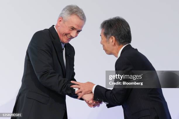 Karl Deppen, chief executive officer of Mitsubishi Fuso Truck & Bus Corp., left, shakes hands with Satoshi Ogiso, chief executive officer of Hino...