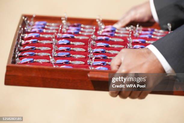 Royal Victorian Order medals are carried ready to be presented by King Charles III to members of the Royal Navy for their part in Queen Elizabeth...