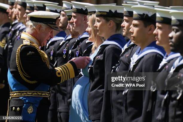 King Charles III presents seven month pregnant Medical Assistant Paisley Chambers-Smith with the Royal Victorian Order to members of the Royal Navy...