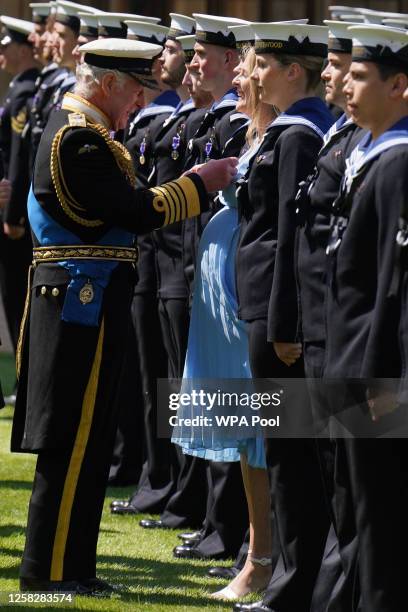 King Charles III presents seven month pregnant Medical Assistant Paisley Chambers-Smith with the Royal Victorian Order to members of the Royal Navy...