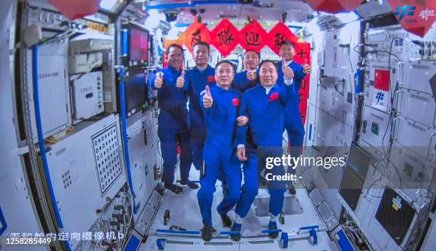 Crew of the Shenzhou-15 spaceflight mission Fei Junlong , Zhang Lu and Deng Qingming take photos with crew of the Shenzhou-16 spaceflight mission...