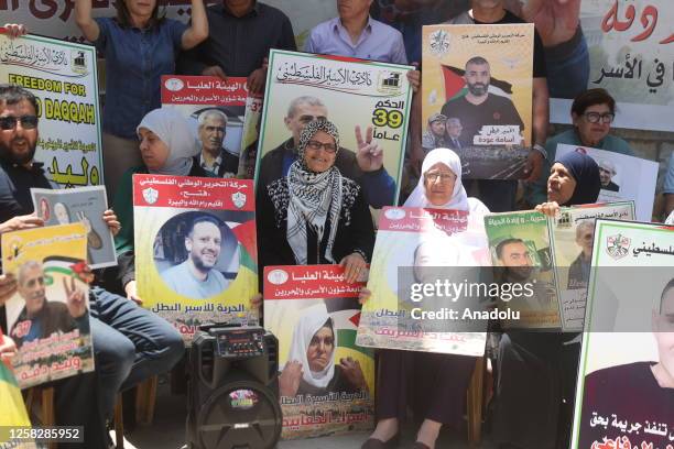 People, holding photos of prisoners, gather for a solidarity demonstration for Palestinian prisoners held in Israeli jails in front of Red Cross...